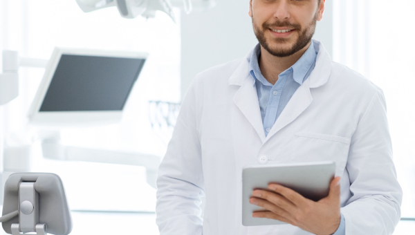 A happy dentist holding the OrthoPhoto dental recordkeeping app